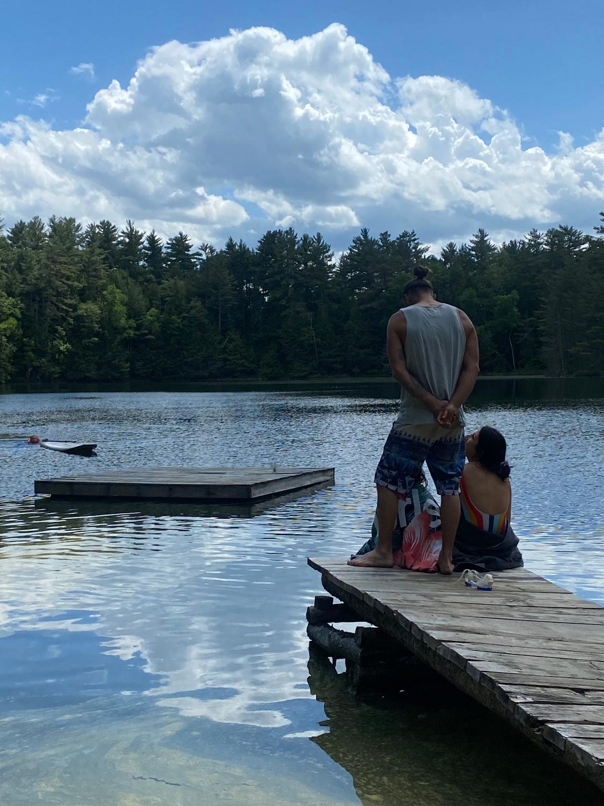 A family seen from behind looking across Pine Lake from the dock
